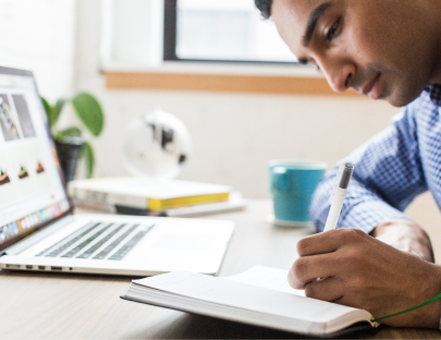Man sitting at desk writing in notebook