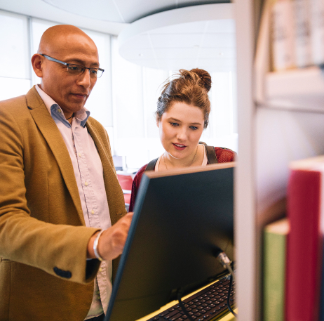 Male educator showing a female student how to search courseware on the computer.