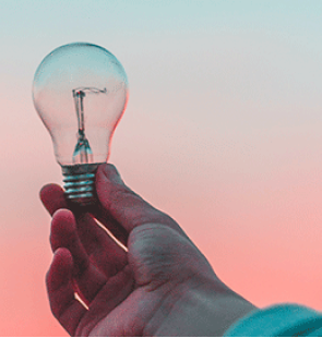 Hand holding an unlit lightbulb.